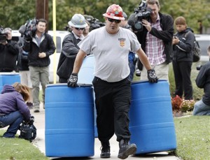 Protect Environmental workers move disposal barrels to a staging area outside the apartment of a healthcare worker who treated Ebola patient Thomas Eric Duncan and tested positive for the disease, Monday in Dallas.Associated Press