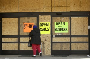 A woman walks into a boarded-up but open business Thursday in Ferguson, Mo. Ferguson and the St. Louis region are on edge in anticipation of the announcement by a grand jury on whether to criminally charge Officer Darren Wilson in the killing of 18-year-old Michael Brown.Associated Press