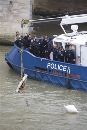 French river police lift the block of stone Thursday from around the oldest bridge in Paris, le Pont Neuf.Associated Press
