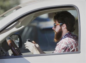 In this Feb. 26, 2013 file photo, a man uses his cell phone as he drives through traffic in Dallas.Associated Press