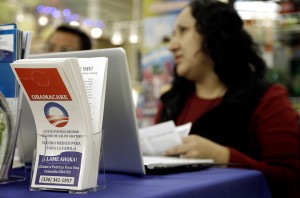 Blue Bridge Benefits LLC agent Patricia Sarabia helps customers interested in Obama Care Saturday at a kiosk at Compare Foods in Winston-Salem, N.C.Associated Press