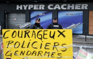 French police officers guard the kosher grocery where Amedy Coulibaly killed four people in a terror attack, in Paris, Wednesday, Jan. 21, 2015. France announced sweeping new measures to counter homegrown terrorism Wednesday, including giving security forces better weapons and protection, going on an intelligence agent hiring spree and creating a better database of anyone suspected of extremist links. (AP Photo/Christophe Ena)