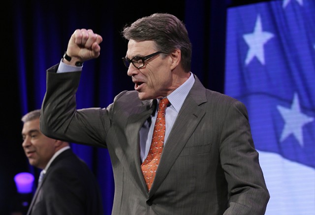 Former Texas Gov. Rick Perry pumps his fist as he walks on stage during the Freedom Summit, Saturday, Jan. 24, 2015, in Des Moines, Iowa. (AP Photo/Charlie Neibergall)