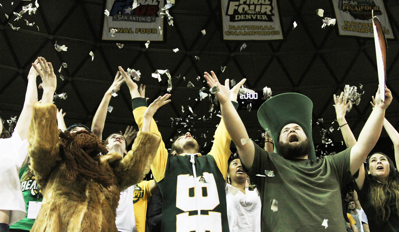 The Bear Pit throws torn up newspapers into the air to get hyped up before the game begins at the Baylor men’s basketball game against Oklahoma University. The Bears won 69-58 against the Sooners on Jan. 24, 2015, in the Ferrell Center.  Skye Duncan | Lariat Photo Editor