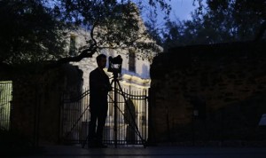 In this Jan. 9, 2014 file photo, Soheil Hamideh is silhouetted against the Alamo as he uses a camera to record images of the Alamo long barracks in San Antonio. A study by a team of Texas A&M-led architecture researchers employing lasers and digital images shows the iconic west facade of the Alamo in downtown San Antonio is slowly eroding. (AP Photo/Eric Gay)