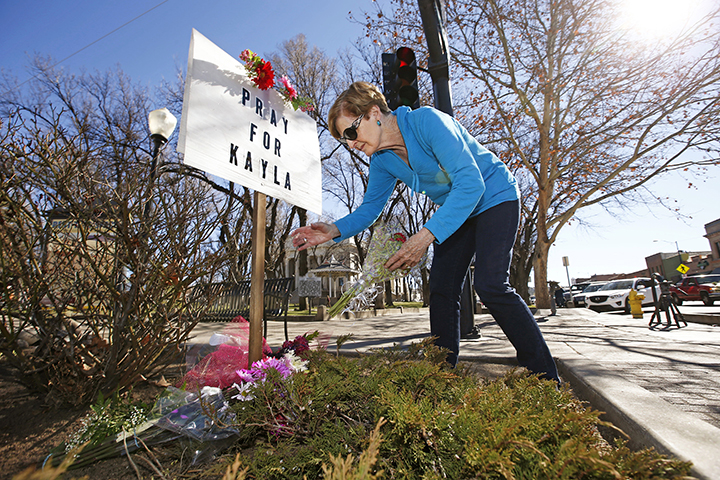Turi Whiting of Minneapolis leaves a bouquet of flowers at a "Pray for Kayla" sign Monday in downtown Prescott, Ariz. Mueller, a 26-year-old American woman held by Islamic State militants, has been confirmed dead, her parents and the Obama administration said Tuesday. The White House said that Mueller's family received a private message from her captors over the weekend and the information contained in that communication was authenticated by the U.S. intelligence community. It was not immediately clear how and when Mueller died.  Associated Press