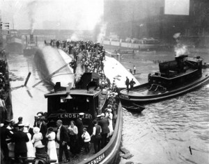 In this July 24, 1915 file photo, passengers are rescued as they stand atop the Eastland passenger ship after the vessel capsized in the Chicago River in downtown Chicago. Film clips have surfaced of the 1915 disaster that left 844 people dead. The first-known footage of the Eastland disaster was spotted by Jeff Nichols, a doctoral student at the University of Illinois at Chicago who was looking through seemingly unrelated material on World War I. (AP Photo)