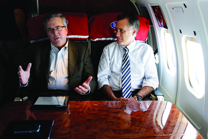 Former Massachusetts Gov. Mitt Romney talks with former Florida Gov. Jeb Bush as they fly on Romney's campaign plane in 2012 to Miami Fla. 