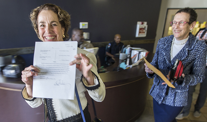 Suzanne Bryant shows off her wedding license certificate as she walks out the Travis County clerk’s office with Sarah Goodfriend on Thursday in Austin. Travis County spokeswoman Ginny Ballard said the marriage occurred Thursday, though it wasn’t immediately clear if the license has legal standing.  Associated Press