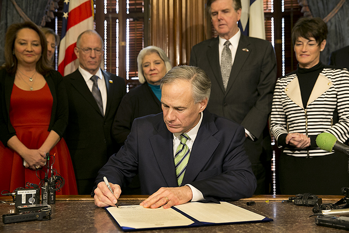 Texas Gov. Greg Abbott, surrounded by lawmakers, signs a proclamation making today, February 2, 2015,  "Chris Kyle Day" in Austin, Texas. Two years after Kyle's death, and days before the man accused of killing him goes to trial, the retired SEAL was honored by his home state.Associated Press