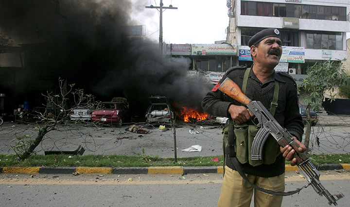 A Pakistani police officer stands guard at the site of a deadly bombing Tuesday in Lahore, Pakistan.  Associated Press