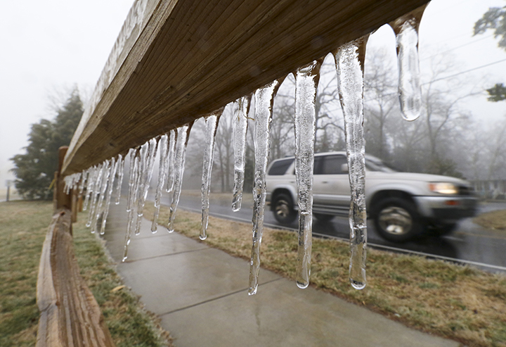 A motorist passes a fence atop Signal Mountain where icicles are forming as rain and freezing temperatures make their way into the Tennessee Valley Monday near Chattanooga.  Associated Press