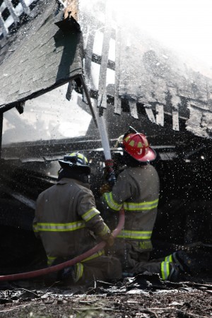 Fire fighters extinguish the remaining embers of a fire at 3 p.m. Monday in the 500 block of 11th St.  Courtesy of Hannah Neumann