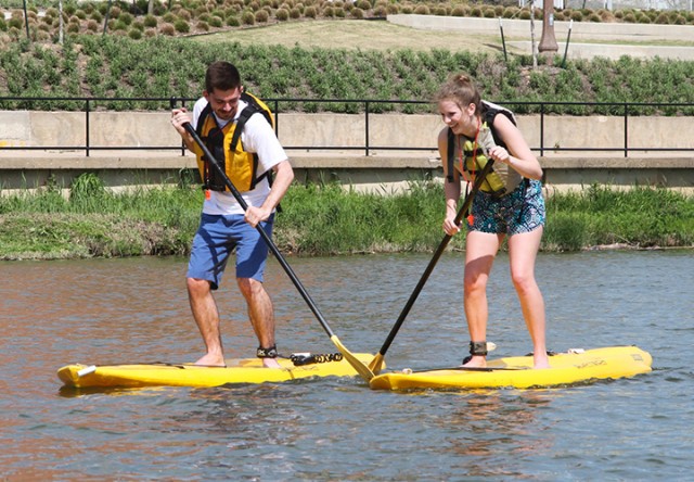 San Antonio freshman Brittany Watts and Houston sophomore Steven Newcomb paddleboard Wednesday afternoon on the Brazos River beside McLane Stadium.  Skye Duncan |Lariat Photo Editor