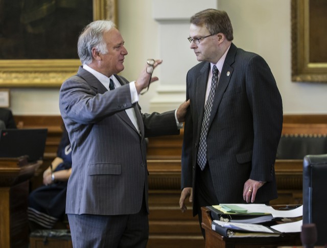 Sen. Kirk Watson, left, debates the language in Sen. Brian Birdwell‘s bill Wednesday during a brief break at Senate chamber at the Texas State Capitol in Austin. The bill aims to expand concealed handguns on campus.  Associated Press