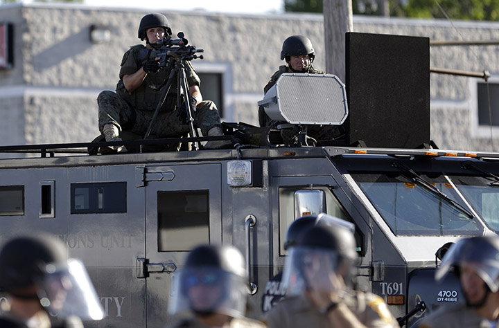 A police tactical team moves in to disperse a group of protesters on Aug. 9, 2014 in Ferguson, Mo.  Associated Press
