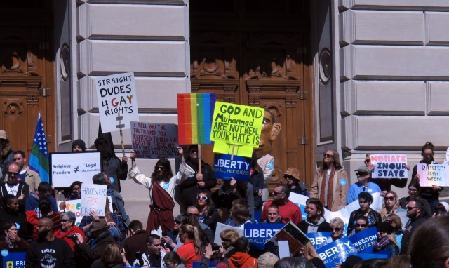 Some of the hundreds of people who gathered outside the Indiana Statehouse on Saturday for a rally against legislation signed Thursday by Gov. Mike Pence stand on the State house’s south steps during the 2-hour-long rally. The law’s opponents say it could sanction discrimination against gay people.  Associated Press