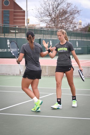Doubles partners sophomore Blair Shankle and No. 10 Ema Burgic celebrate their point won against TCU in their doubles match Sunday March 22 at the Hurd Tennis Center.  Jess Schurz | Lariat Photographer