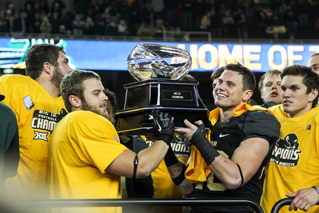 Baylor football players hoist the Big 12 title trophy after winning the Big 12 on Dec. 7, 2014. The Big 12 may add a championship game for 2016.  Kevin Freeman | Lariat Photographer