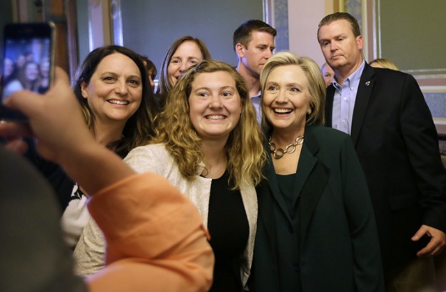 Democratic presidential candidate Hillary Rodham Clinton poses Wednesday for a photo with Simpson College student MacKenzie Bills, center, after meeting with Iowa Democratic Party lawmakers at the Statehouse, Wednesday, April 15, 2015, in Des Moines, Iowa.  Associated Press