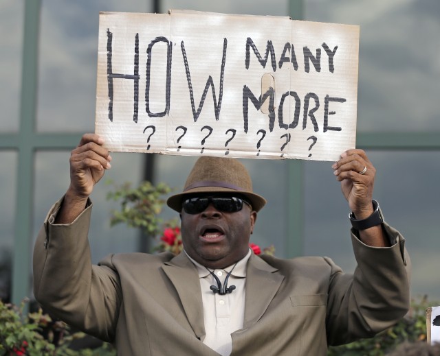 Rev. Arthur Prioleau holds a sign during a protest in the shooting death of Walter Scott on Wednesday at city hall in North Charleston, S.C. Scott was killed by a North Charleston police officer after a traffic stop on Saturday. The officer, Michael Thomas Slager, has been charged with murder.  Associated Press