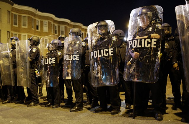 Police stand in formation as a curfew approaches, Tuesday in Baltimore, a day after the unrest that occurred following Freddie Gray’s funeral. Gray died of a severe spinal cord injury after police arrested him.  Associated Press