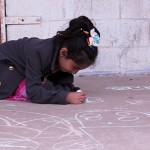 Francis Gomez, 6, diligently draws with chalk.