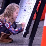 Bella Ives-Bland, 6, draws on the board of hope.
