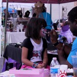 Mila Jones, 6, gets her face painted at a booth on Elm Avenue.