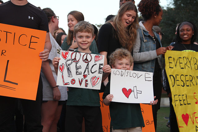 Alden and Syler, children of Dr. Ryan Richardson, associate chaplain and director of worship and chapel, hold signs at the sit-in on Nov. 10 at Fountain Mall.