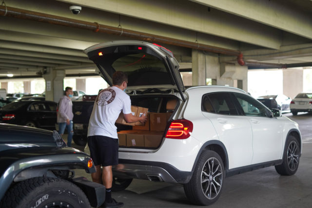 Baylor Pi Kappa Phi unloads 21,000 bottles of hand sanitizer they received from Baylor Scott and White at the East Village Parking Garage Thursday afternoon. They will distribute them to greek life first and then every residence hall on campus. Brittney Matthews | Photo Editor