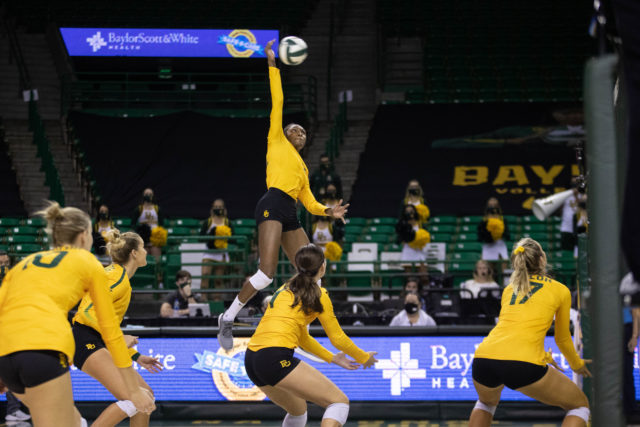 Baylor senior outside hitter Yossiana Presley spikes the ball during Baylor's winning game against West Virginia. Brittney Matthews | Photo Editor