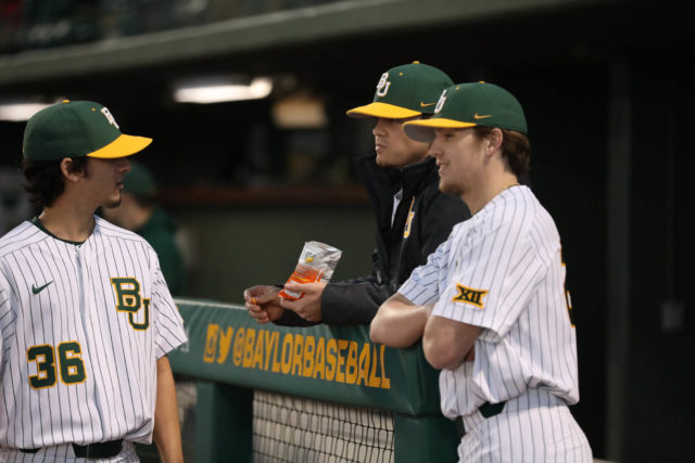 Troy Montemayor, Kyle Hill and Hayden Kettler chat in the dugout prior to a Baylor baseball game against Houston Baptist in 2018. Lariat File Photo