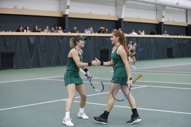 Baylor junior Alicia Herrero Linana and junior Mel Krywoj high five after winning a match against Illinois during the 2020 season.