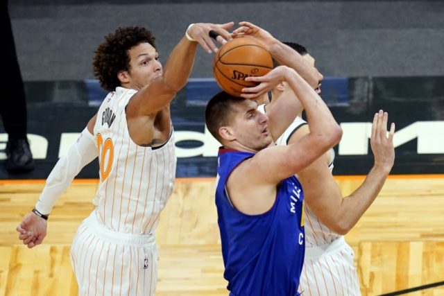 Orlando Magic forward Aaron Gordon, left, comes from behind to block as shot by Denver Nuggets center Nikola Jokic during the first half of an NBA basketball game, Tuesday, March 23, 2021, in Orlando, Fla. (AP Photo/John Raoux)(ASSOCIATED PRESS)