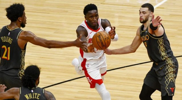 Houston Rockets guard Victor Oladipo, center, passes between Chicago Bulls forward Thaddeus Young, left, and guard Zach LaVine, right, during the second half of an NBA basketball game Monday, Jan. 18, 2021, in Chicago. (Matt Marton/AP)