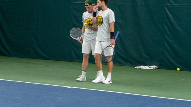 No. 12 duo partners junior Finn Bass (left) and fifth-year senior Sven Lah (right) strategize during their doubles match against No. 2 University of Tennessee