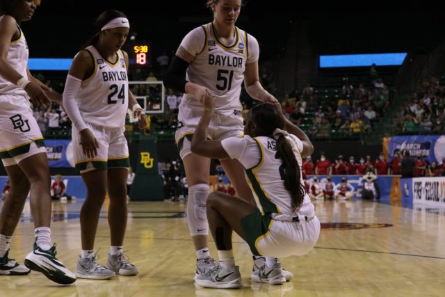 Senior forward Caitlin Bickle helps junior guard Ja'Mee Asberry get back to her feet after drawing a foul against South Dakota March 20 in the Ferrell Center.
Grace Everett | Photographer