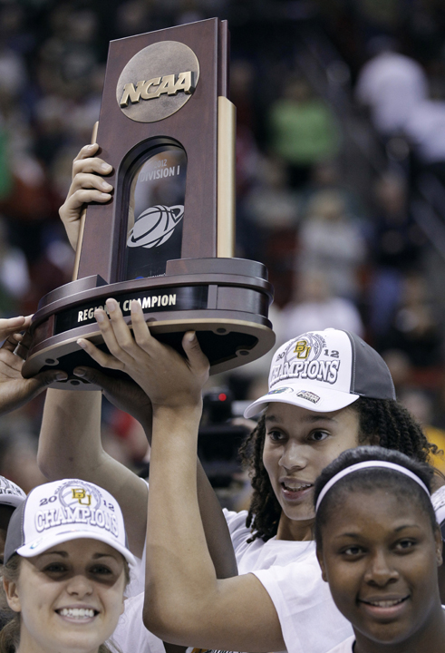 Baylor's Brittney Griner holds the trophy as she and teammate celebrate after an NCAA women's college basketball tournament regional final against Tennessee, Monday, March 26, 2012, in Des Moines, Iowa. Baylor won 77-58. (AP Photo/Charlie Neibergall)