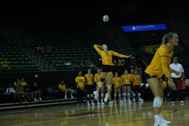 Riley Simpson (#14) spiking the ball against