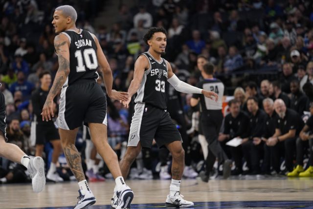 San Antonio Spurs forward Jeremy Sochan (10), left, celebrates with guard Tre Jones (33) after a Spurs basket during the second half of an NBA basketball game against the Minnesota Timberwolves, Monday, Oct. 24, 2022, in Minneapolis. (AP Photo/Abbie Parr)