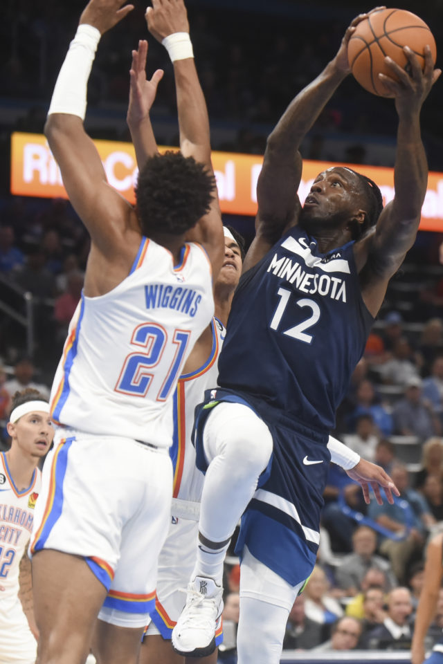 Minnesota Timberwolves forward Taurean Prince (12) goes up for a shot over Oklahoma City Thunder forward Aaron Wiggins (21) in the first half of an NBA basketball game, Sunday, Oct. 23, 2022, in Oklahoma City. (AP Photo/Kyle Phillips)