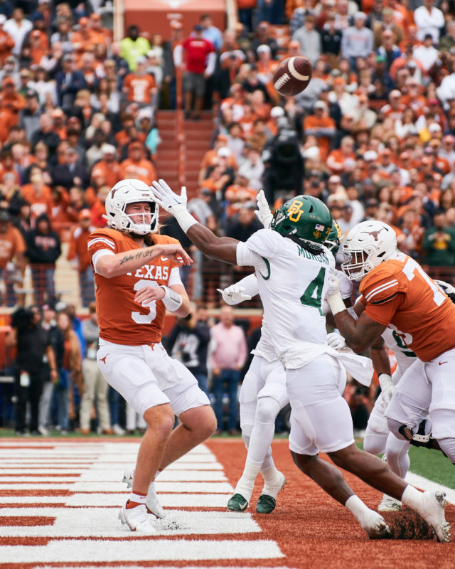 Texas' redshirt freshman quarterback Quinn Ewers (3), pressured by fifth-year senior safety Christian Morgan, tosses the ball out of play with no receiver in the area while in the pocket, resulting in a safety in the first quarter of a conference game against No. 23 University of Texas on Nov. 25, 2022 at Darrell K. Royal Memorial Stadium in Austin. Josh McSwain | Roundup