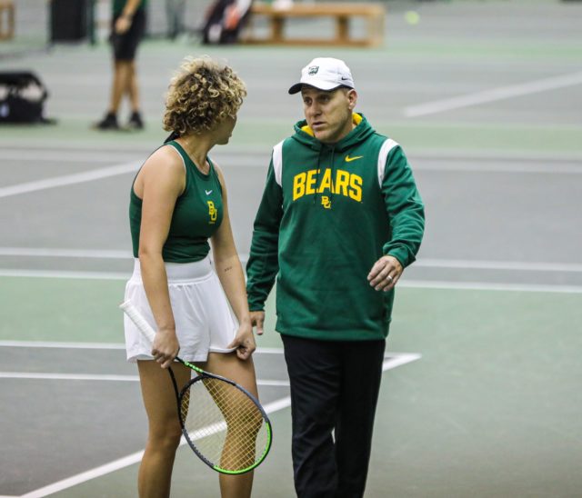 Head coach Joey Scrivano (right) and freshman Daniella Dimitrov (left) discuss the game plan during her singles match against the University of Texas Rio Grande Valley on Jan. 21, 2023, in the Hawkins Indoor Tennis Center. 
Kenneth Prabhakar | Photo Editor