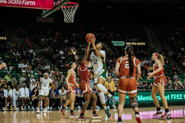 Freshman forward Bella Fontleroy (22) scores a left-handed layup over a Longhorn defender during a conference game against No. 25 University of Texas on Feb. 22, 2023 in the Ferrell Center. 
Kenneth Prabhakar | Photo Editor