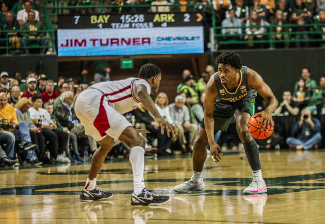 Redshirt senior guard Adam Flagler (10) controls possession of the ball with his dribble during a Big 12/SEC Challenge game against the University of Arkansas on Jan. 28, 2023 in the Ferrell Center.
Kenneth Prabhakar | Photo Editor