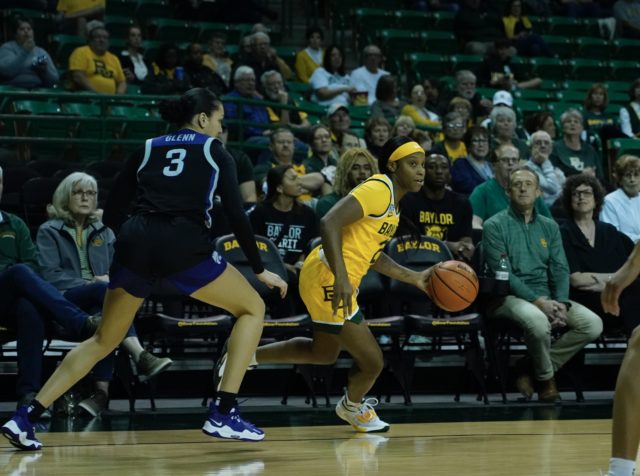 Graduate student guard Ja'Mee Asberry (21) drives to the middle during a conference game against Kansas State University on Jan. 19, 2023 in the Ferrell Center. 
Grace Everett | Photographer