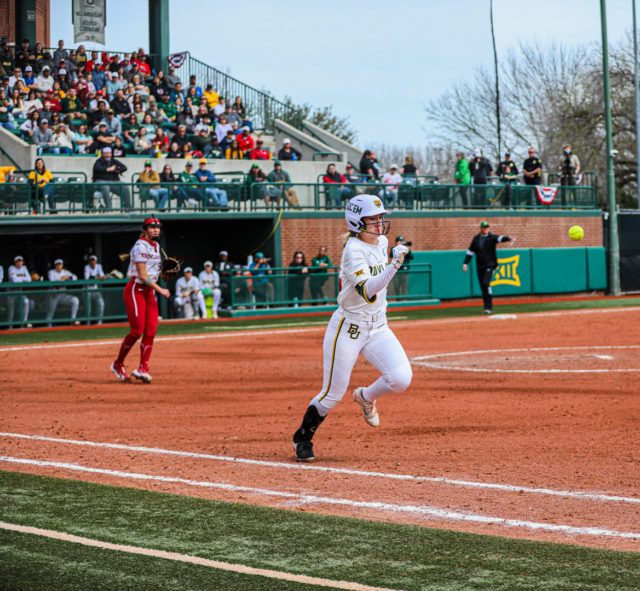 Junior utility player Emily Hott (4) runs toward the first base bag during a game against No. 1 University of Oklahoma as part of the Getterman Classic, Sunday, Feb. 19, 2023, at Getterman Stadium.
Kenneth Prabhakar | Photo Editor