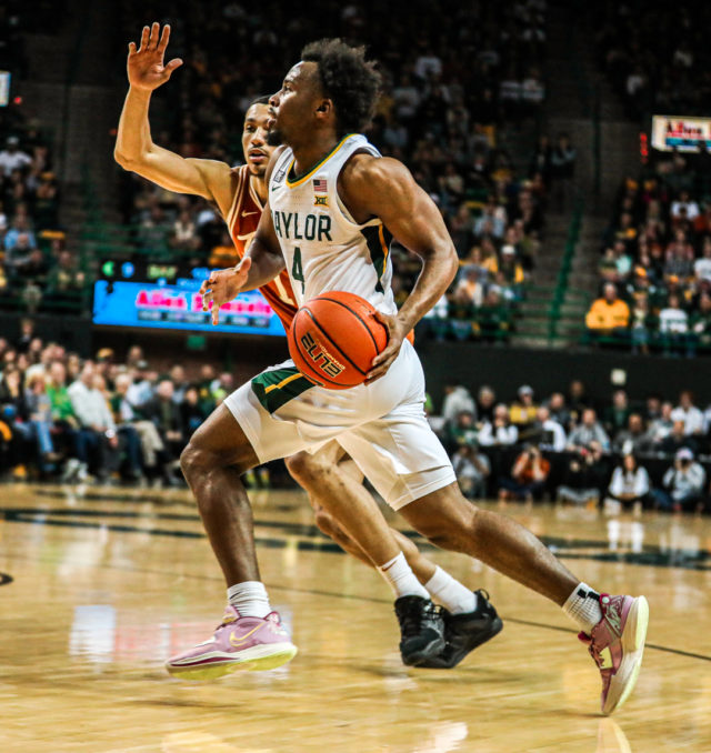 Junior guard LJ Cryer (4) gathers his dribble and goes toward the basket during a conference game against No. 8 University of Texas, Saturday, Feb. 25, 2023, in the Ferrell Center.Kenneth Prabhakar | Photo Editor