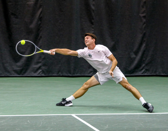 Junior Tadeas Paroulek extends his arms and legs out to make contact with the ball during a non-conference match against No. 3 Texas Christian University, on Feb. 8, 2023, in the Hawkins Indoor Tennis Center.
Kenneth Prabhakar | Photo Editor